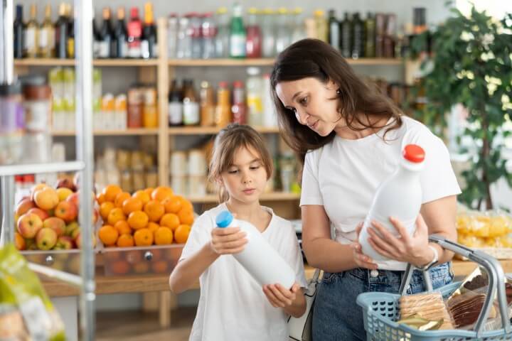 A child and adult in a grocery store with milk